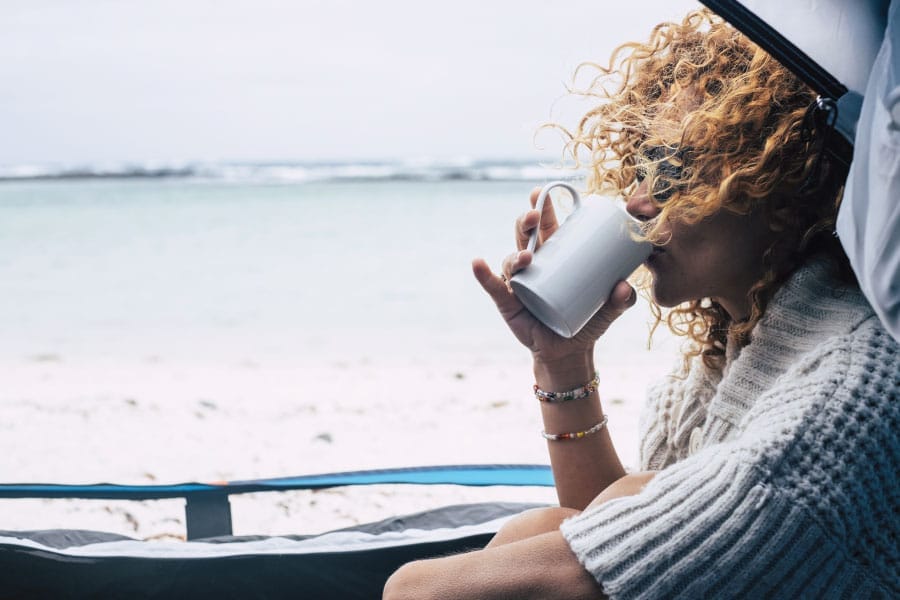 Woman drinking kava in a tent on the beach