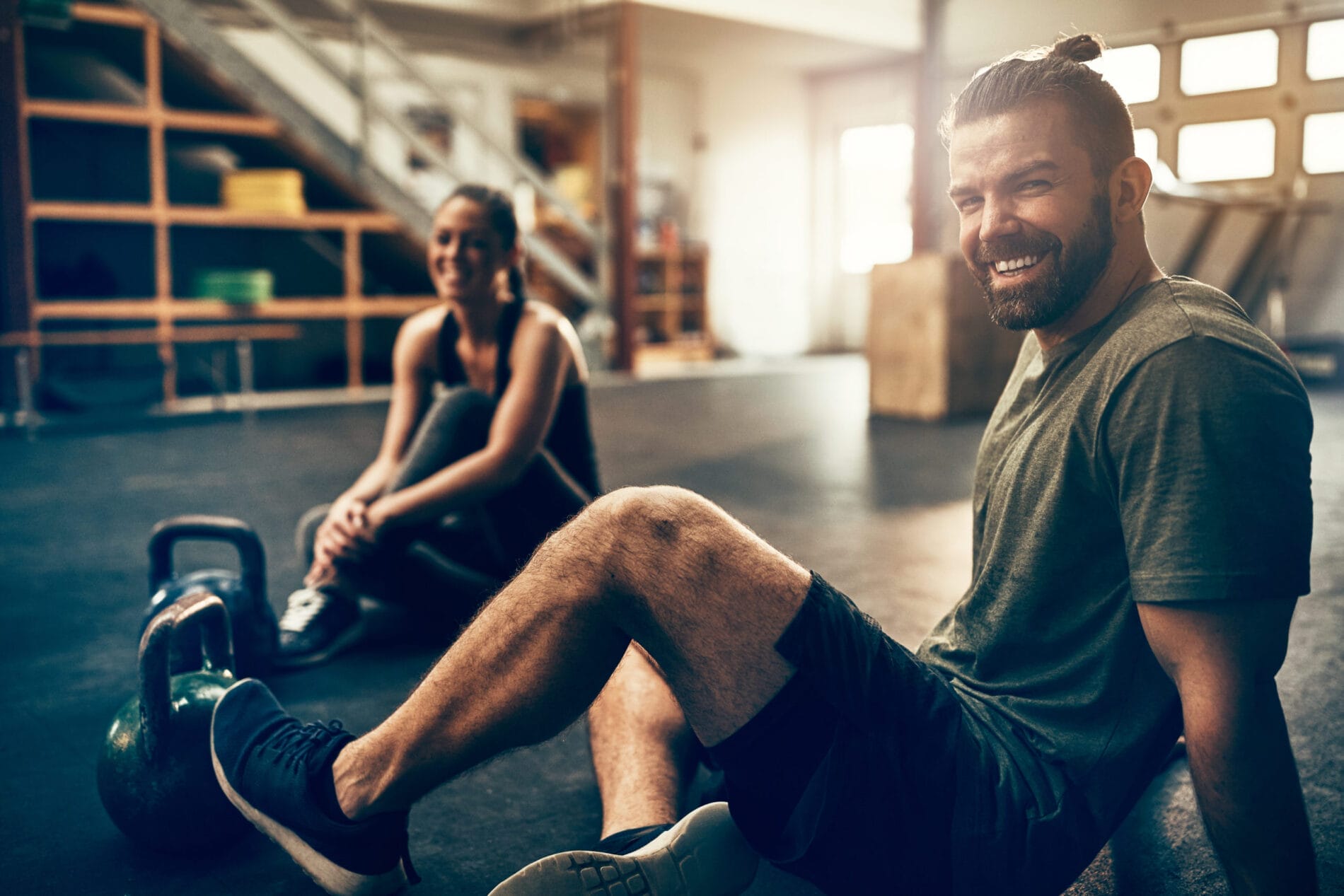 Man and woman relaxing in gym after a workout